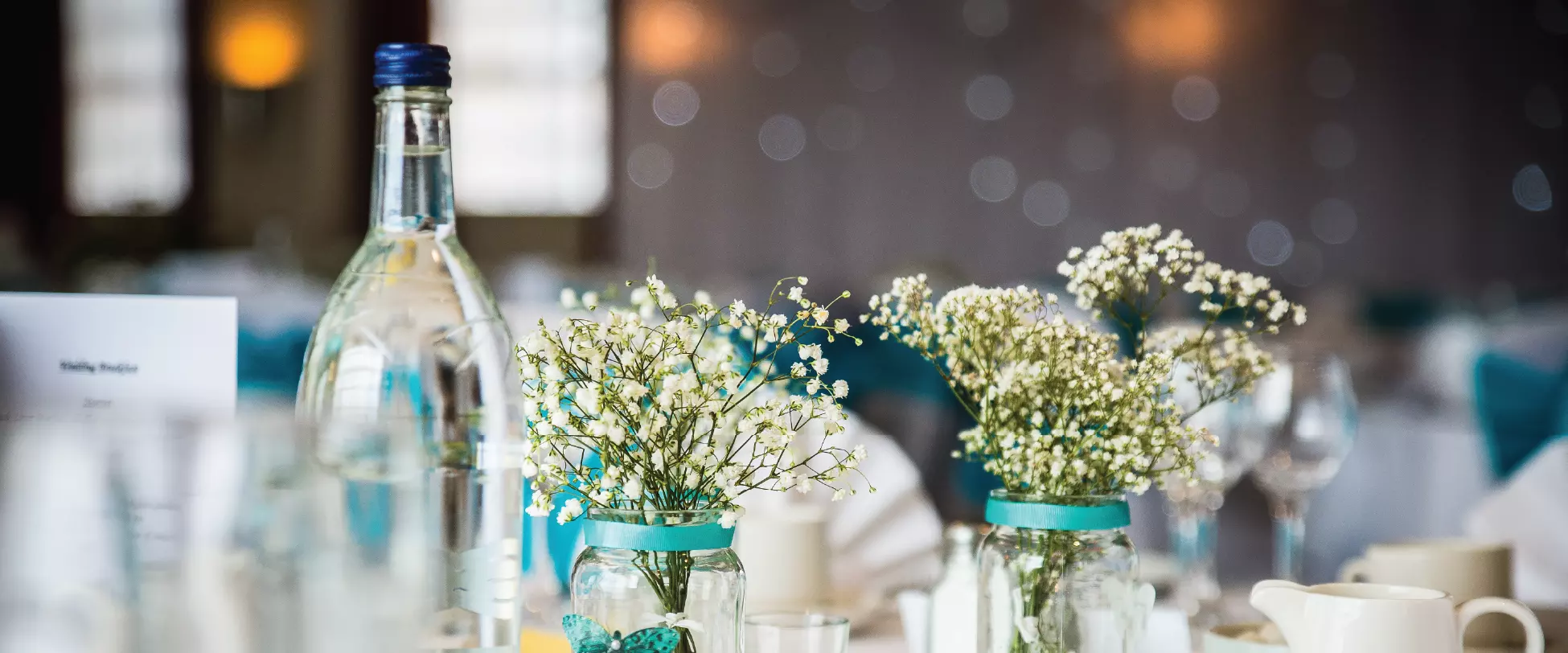 A wedding table dressed with flowers, plates and glasses.